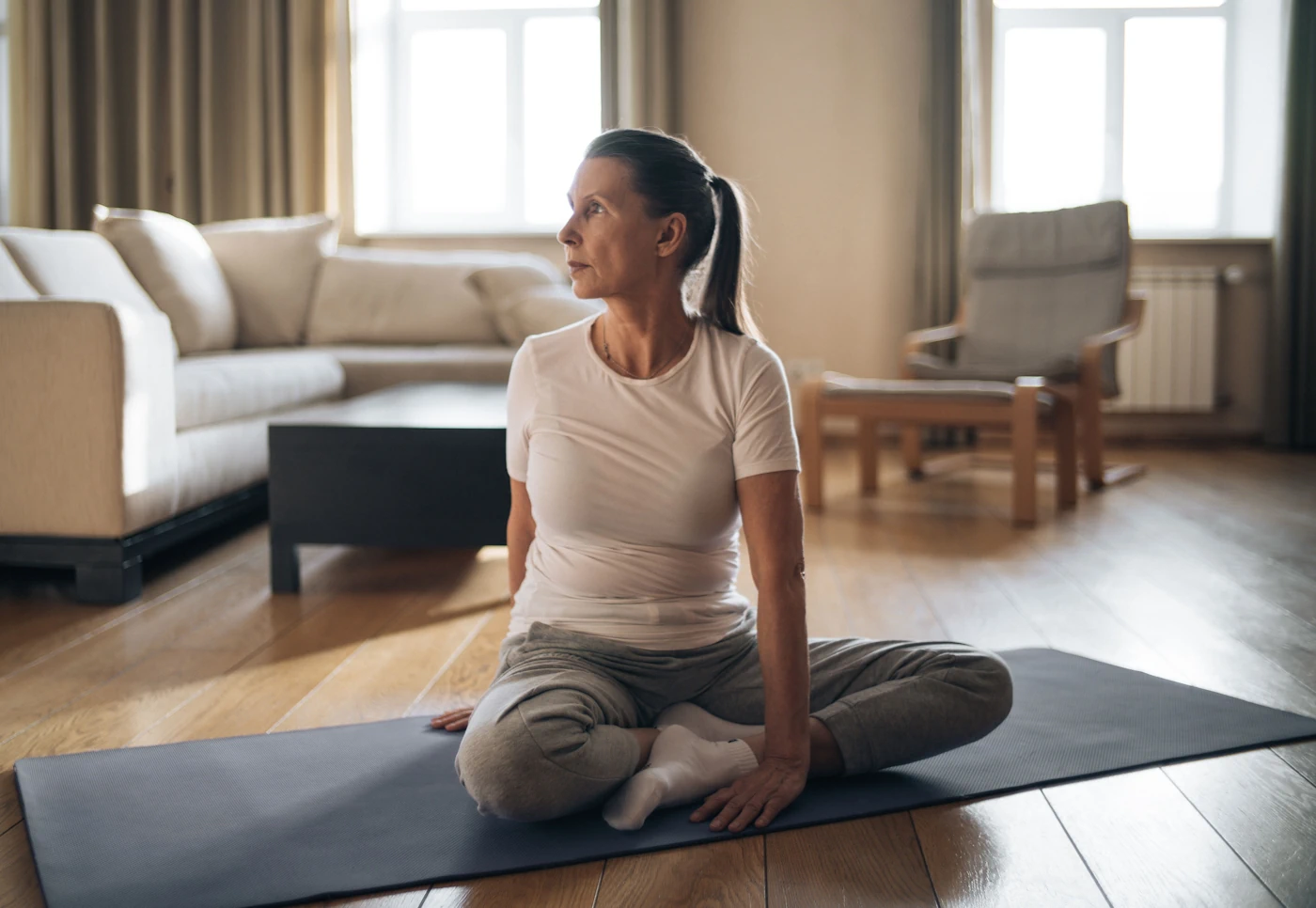Mujer mayor sentada en casa preparándose para meditar